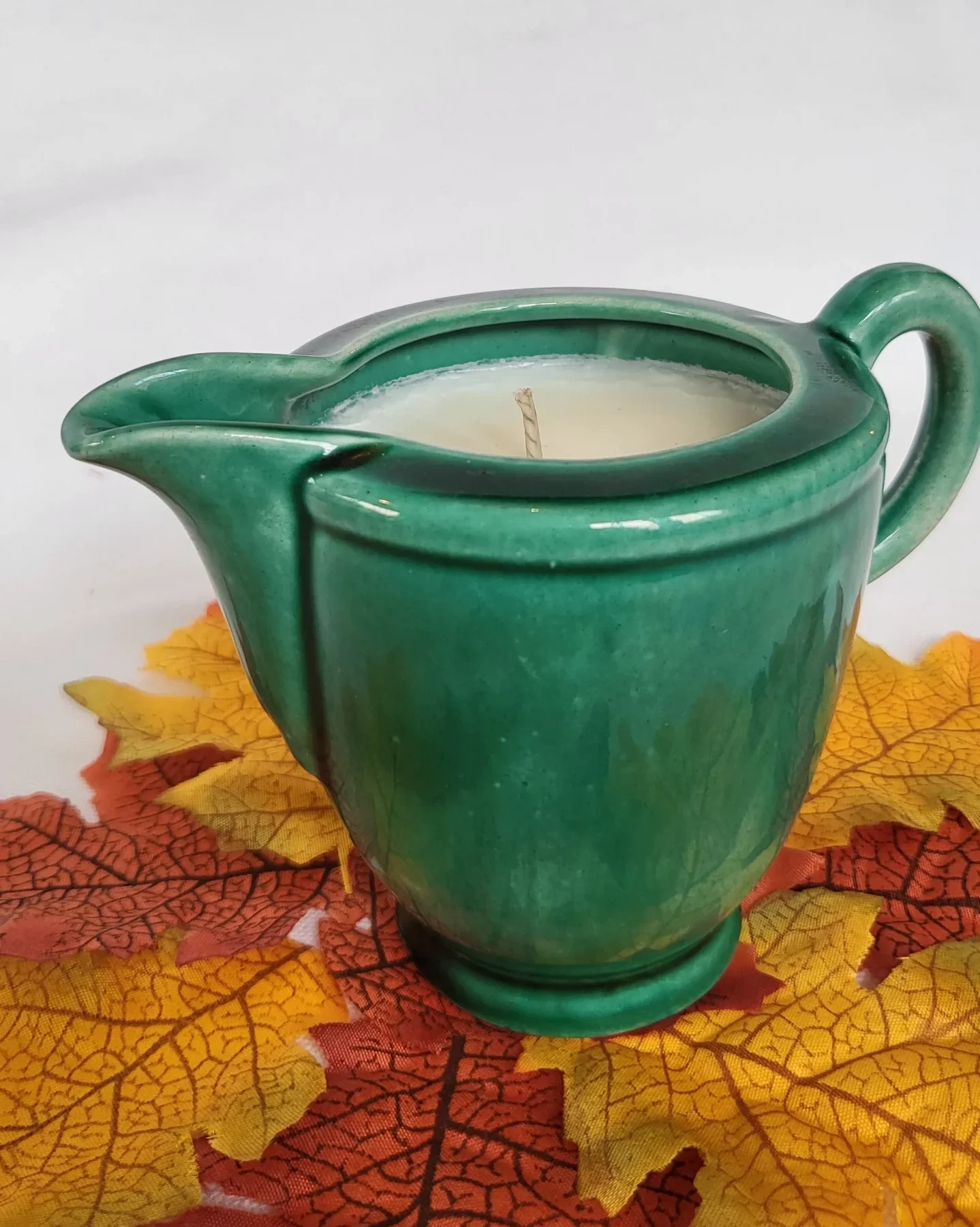 bougie naturelle parfum "sapin enneigé" coulée dans un pot à lait vert en céramique vintage