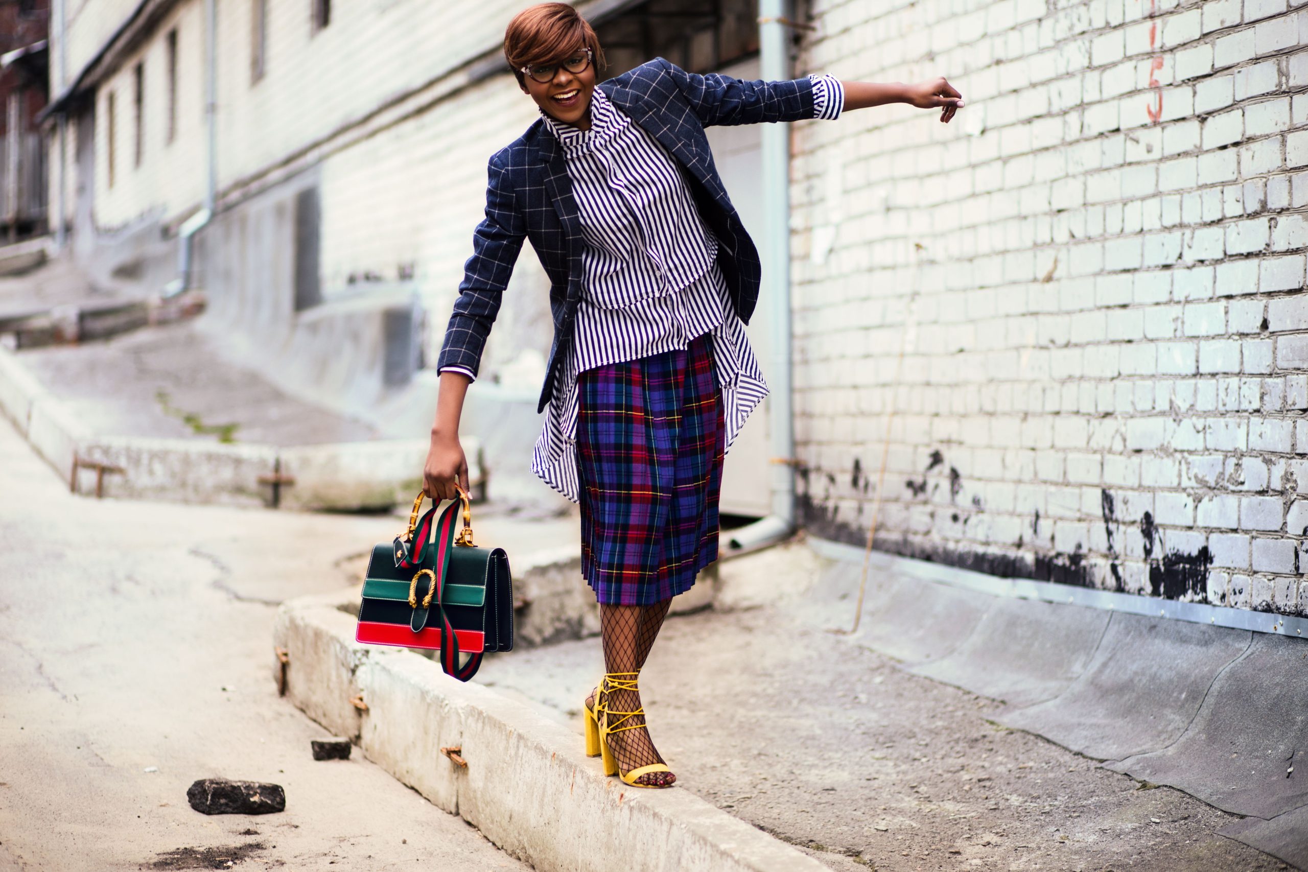 Femme stylisée en blazer et jupe carreaux dehors