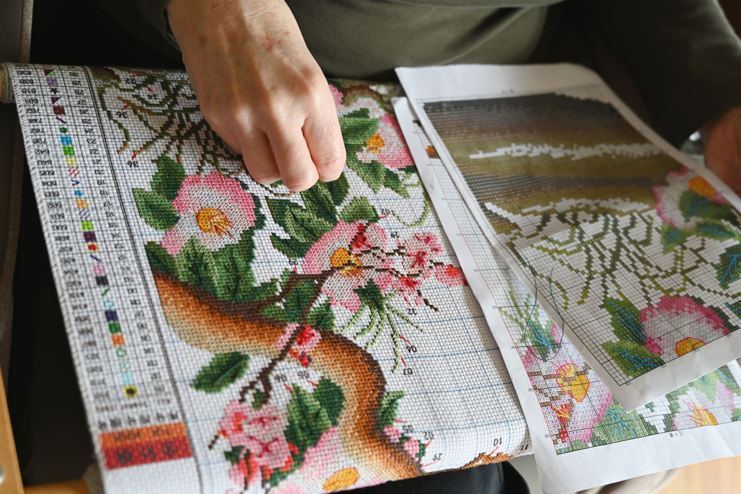 Mains broder motif floral point croix