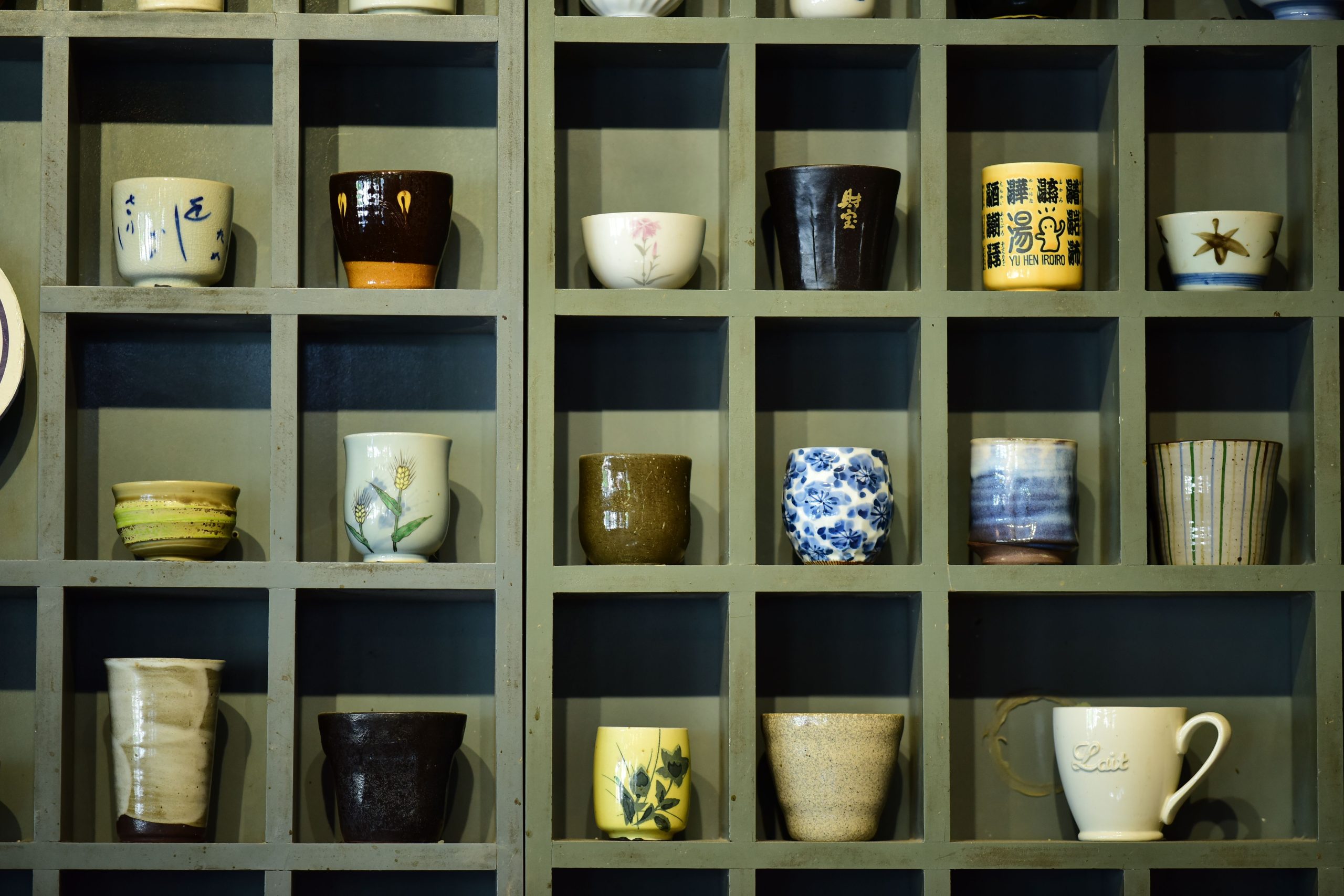 Collection de mugs colorés sur étagère bois
