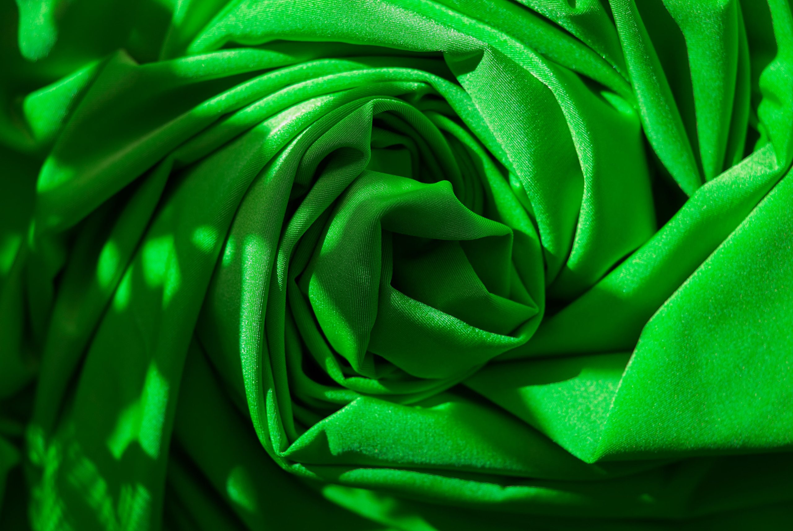 Plis de tissu vert formant un motif abstrait